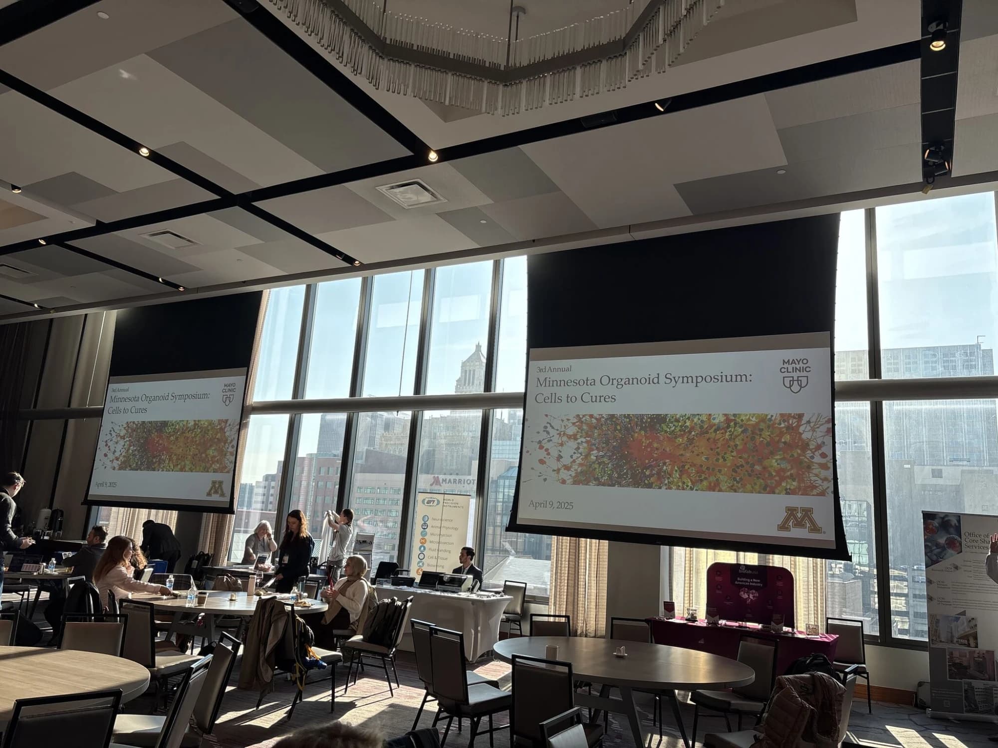 Symposium ballroom with “Minnesota Organoid Symposium: Cells to Cures” on the screens