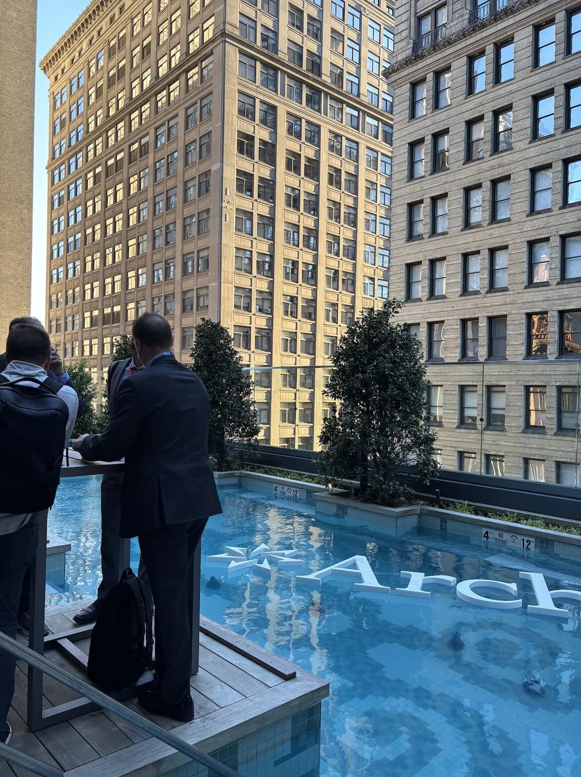 Attendees networking at a rooftop pool reception